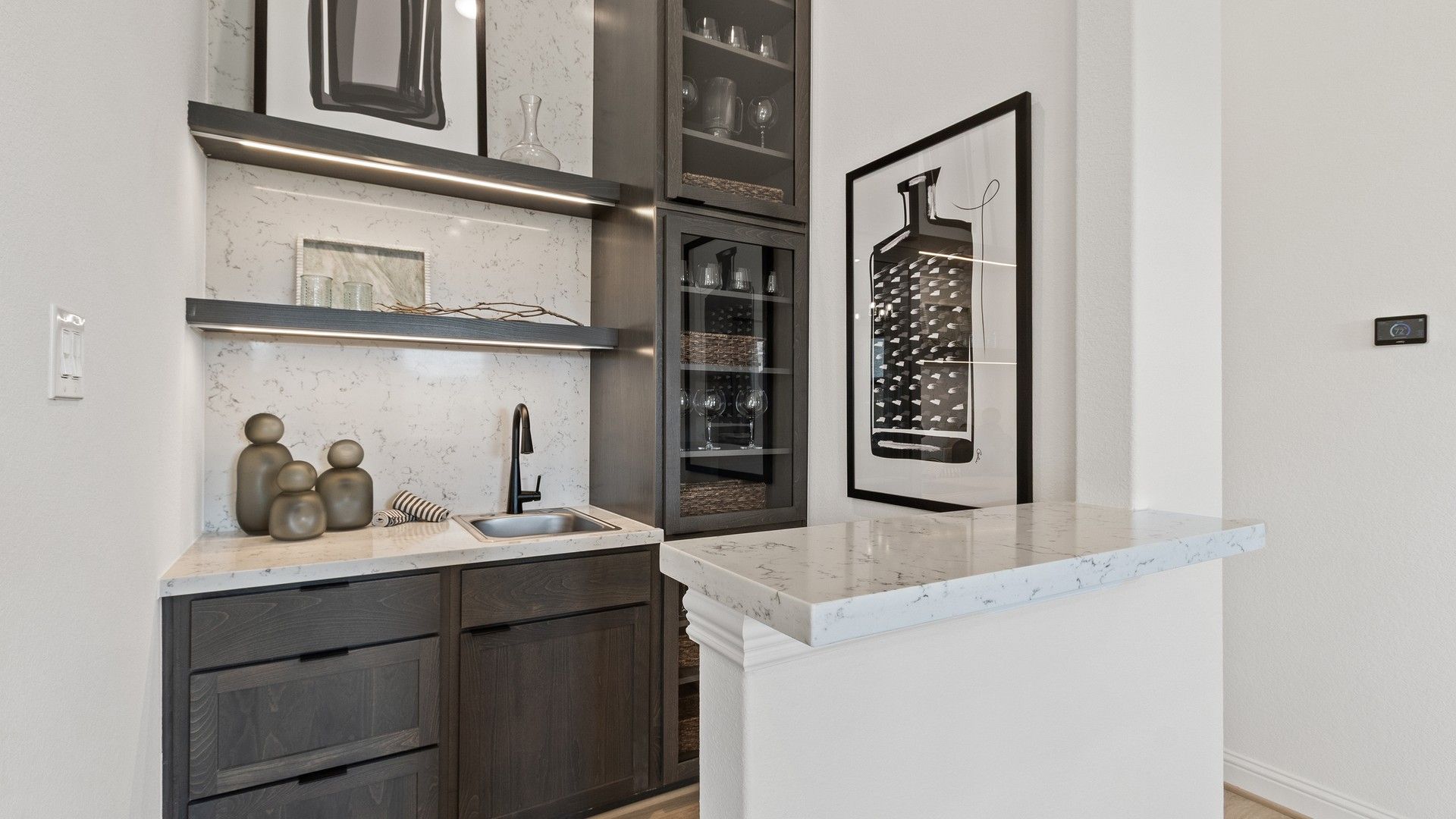Sleek dark wood cabinetry and marble surfaces epitomize elegance in Oakwood Estates' stylish wet bar.