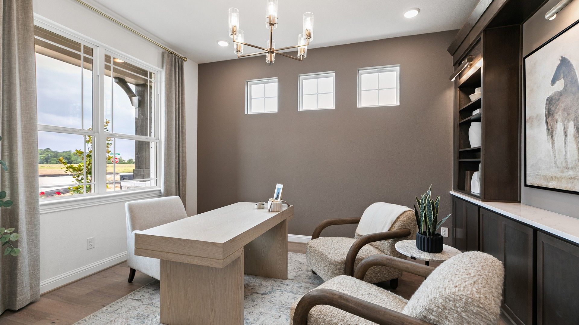 Luxurious study features plush seating, sleek wood accents, and elegant built-ins in Katy Lakes.