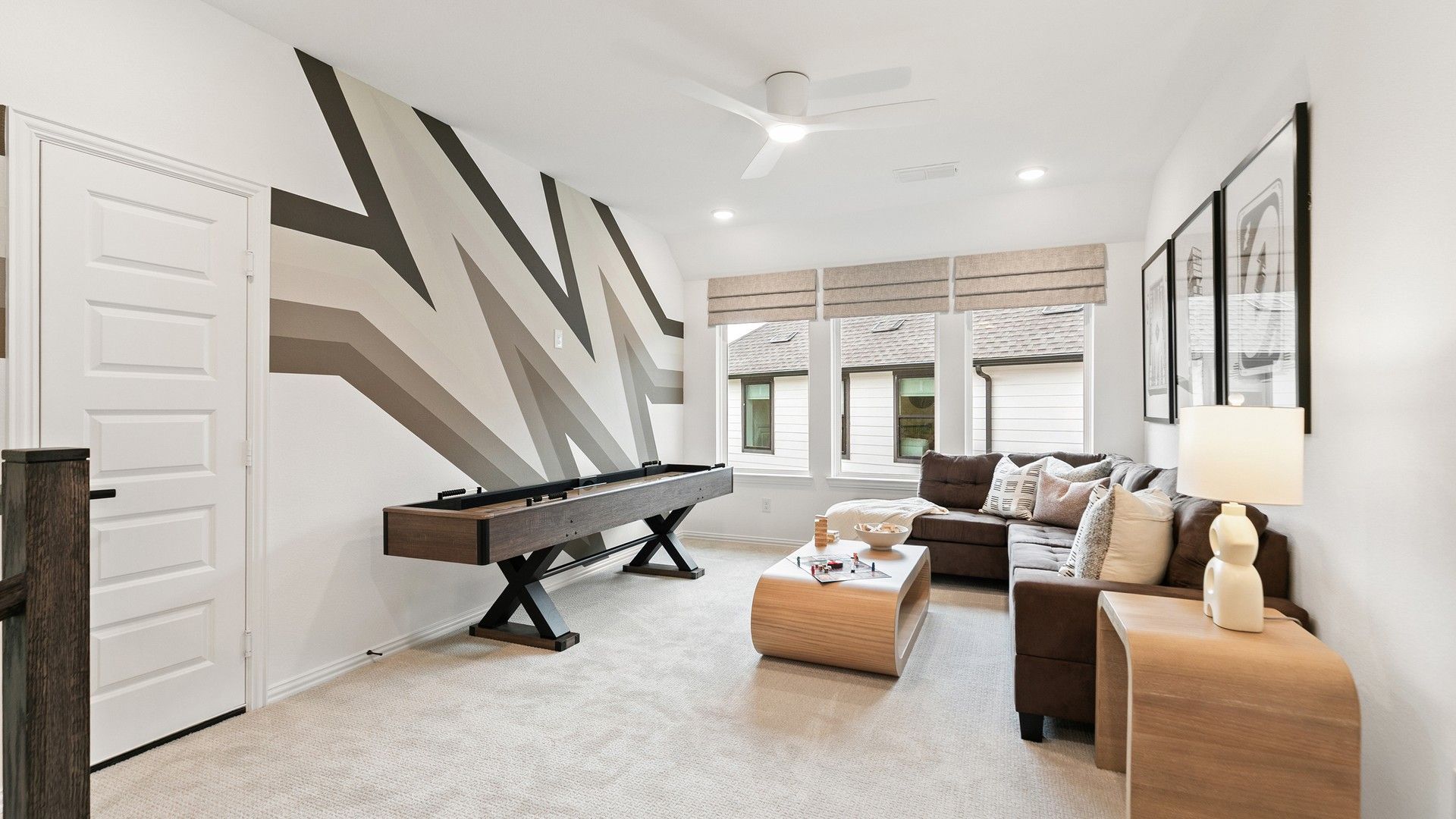 Experience elegance with a zigzag accent wall and sleek shuffleboard in Katy Lakes.