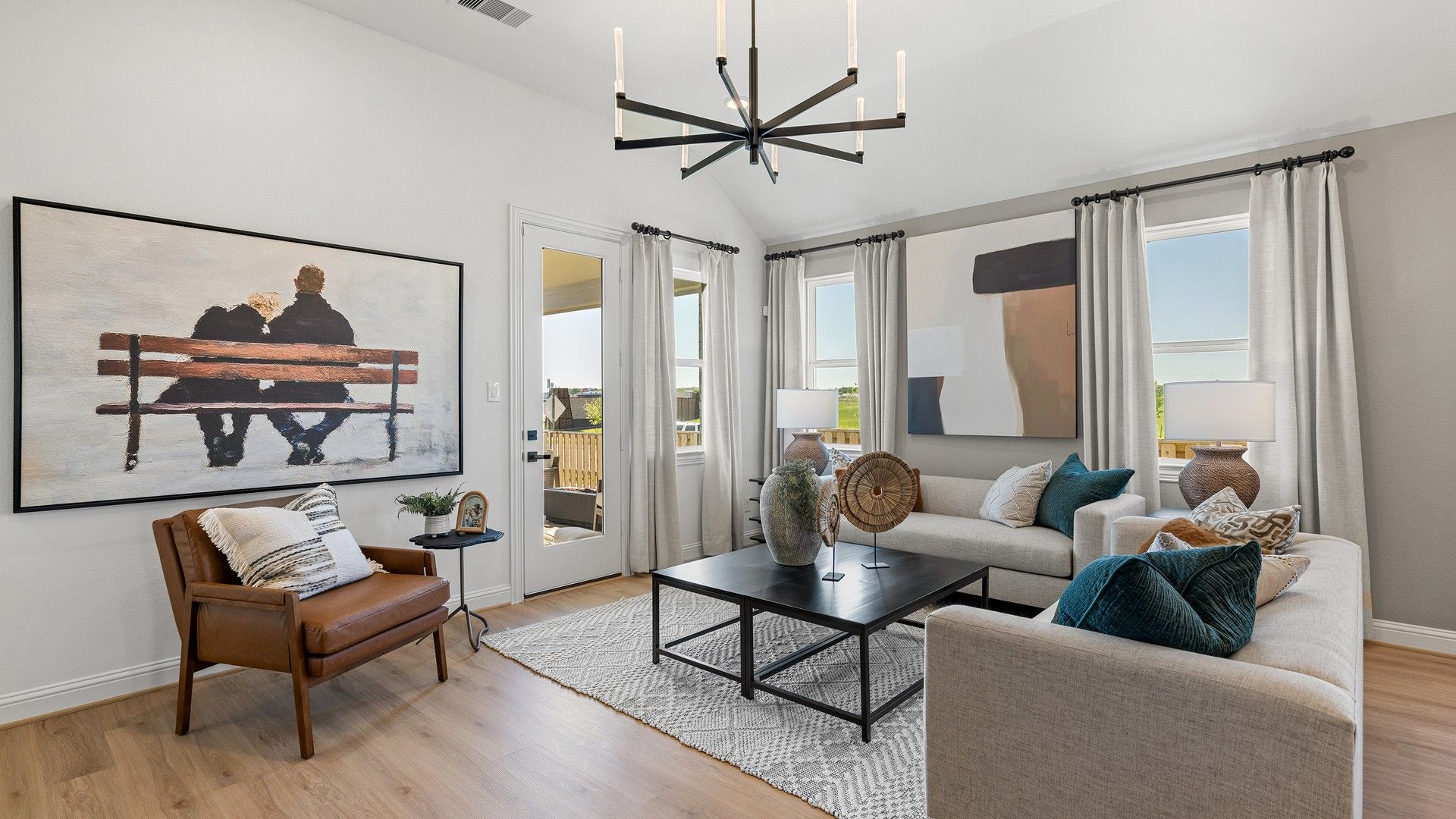 Elegant living space in Southern Pointe featuring a sleek chandelier, modern art, and refined furnishings.