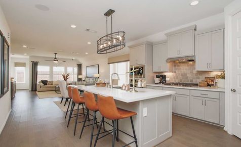 Cypress Green gem features elegant cabinetry, island bar, sleek pendant lighting, and luxurious hardwood floors.
