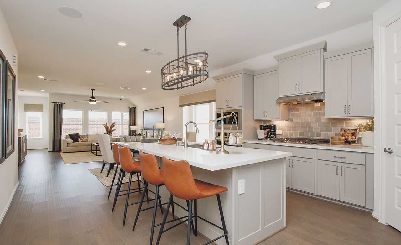 Cypress Green gem features elegant cabinetry, island bar, sleek pendant lighting, and luxurious hardwood floors.