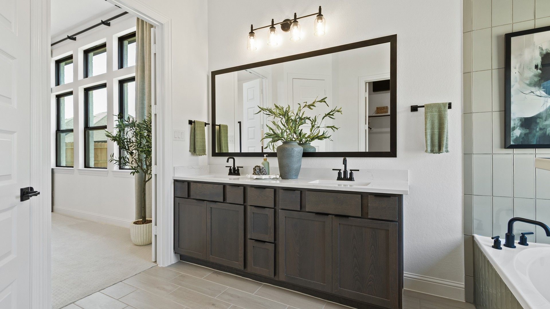 Luxurious dark wood vanity complements chic fixtures in Oakwood Estates.