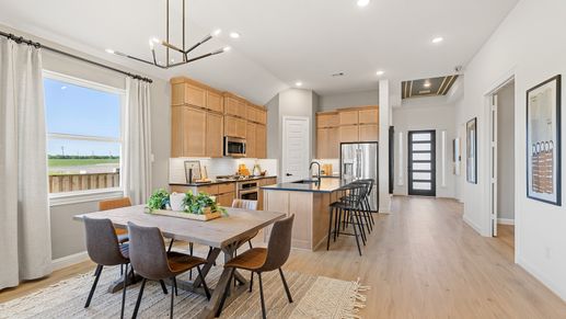 Experience luxury in Southern Pointe. Light wood cabinets and chic lighting define modern elegance.