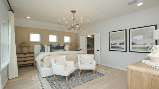 Sophisticated bedroom showcases elegant chandelier and serene decor in Ellis Cove community.