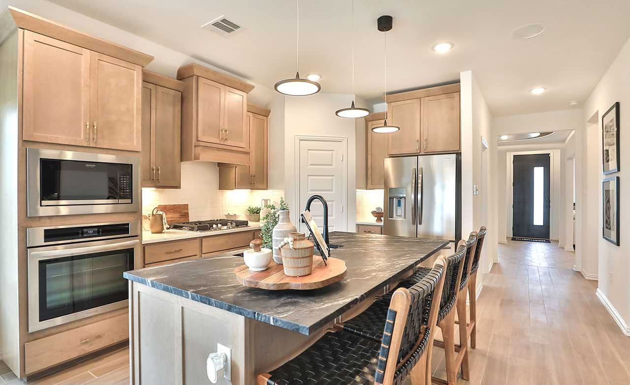 Elegant Bridgeland kitchen with sleek black marble counters, stainless appliances, and custom wood cabinetry.