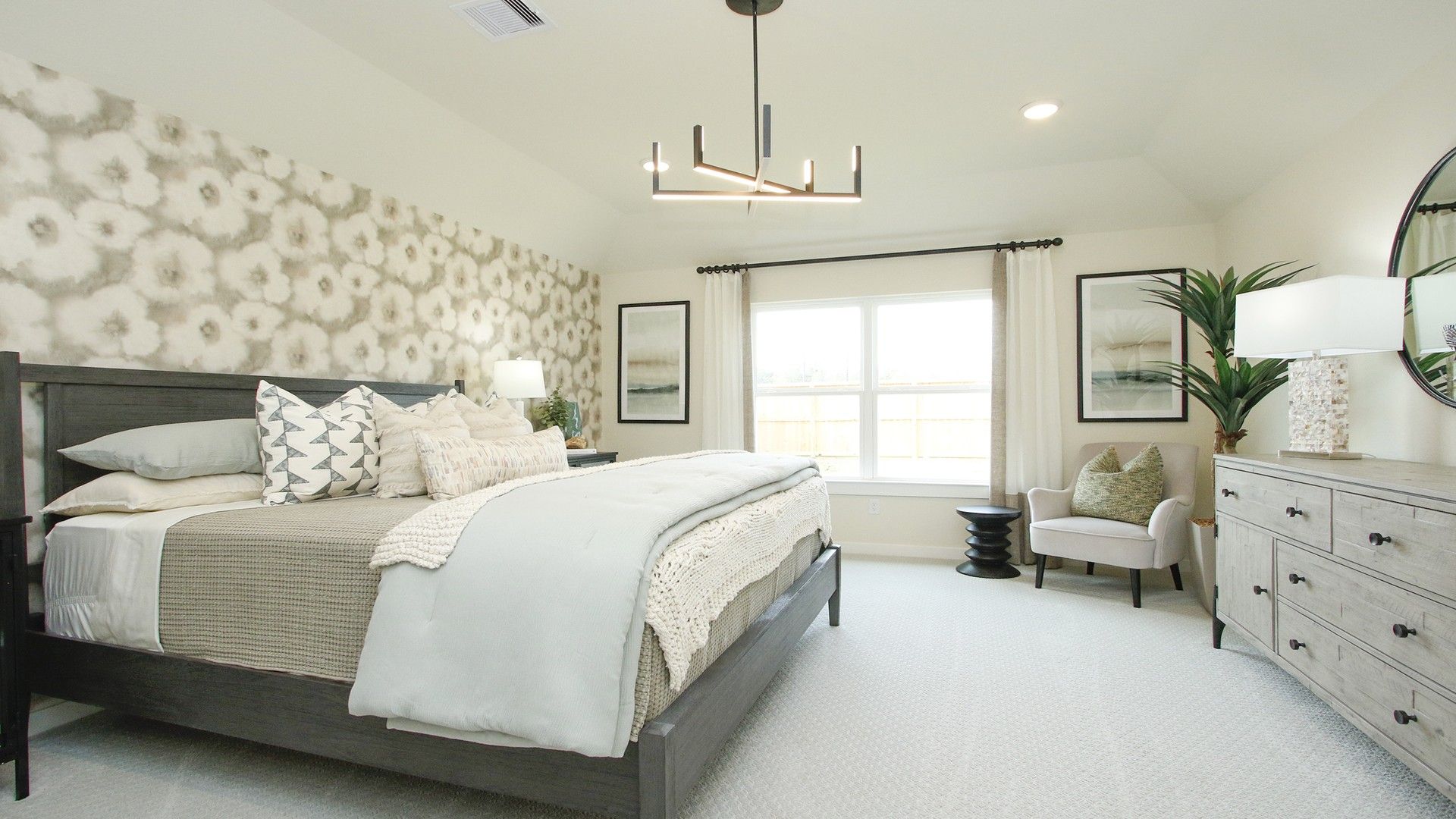 Embrace luxury with chic lighting and a bold accent wall in Colony at Pinehurst's serene bedroom.