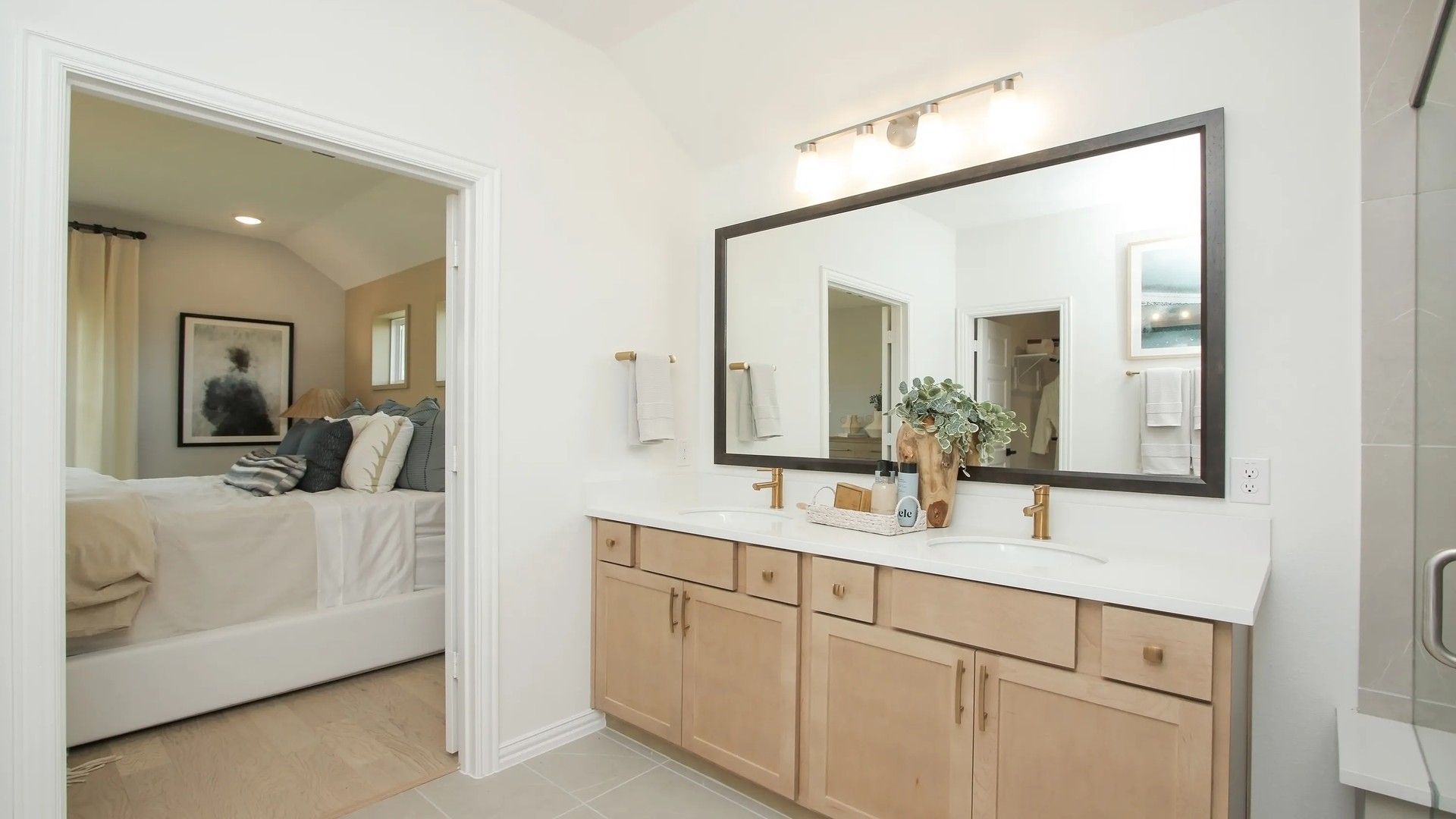 Experience refined living with a chic double vanity and gold-accented fixtures in Ellis Cove's luxurious bathroom.