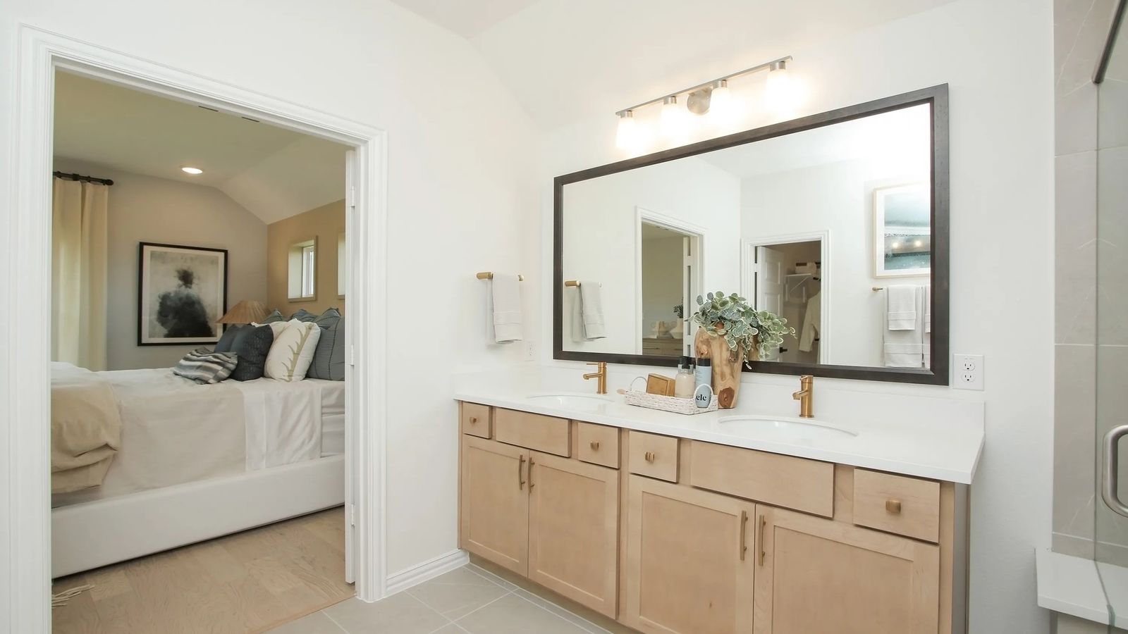 Experience refined living with a chic double vanity and gold-accented fixtures in Ellis Cove's luxurious bathroom.