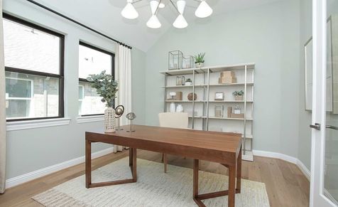 Elegant office with sleek wooden desk and expansive windows in Sunterra community.