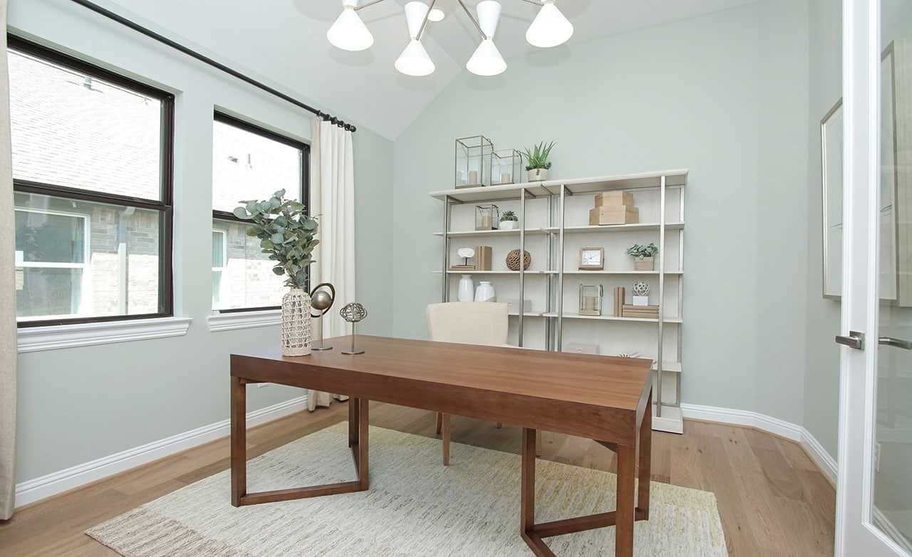 Elegant office with sleek wooden desk and expansive windows in Sunterra community.