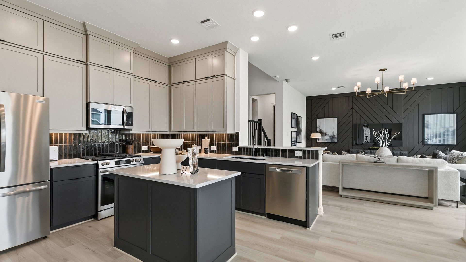 Elegant modern kitchen with premium finishes, island, and wood accent wall in Park at Eldridge, Texas.
