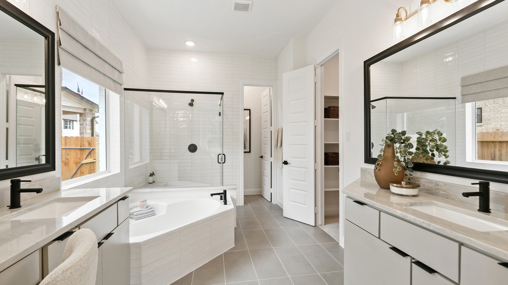 Dual vanity elegance meets sleek tile and glass shower in this Katy Lakes sanctuary.