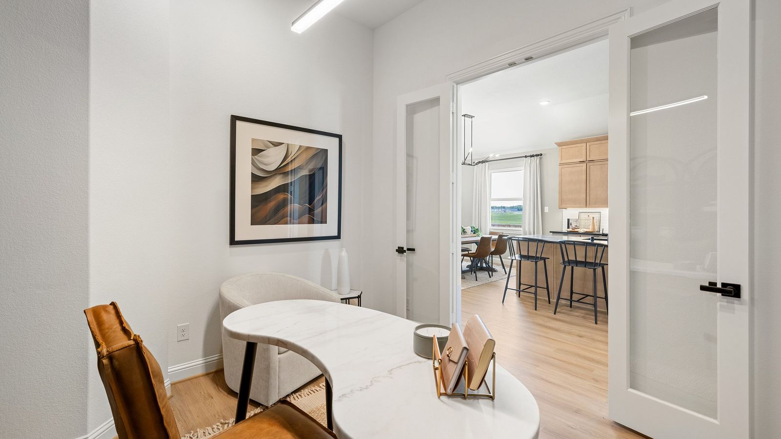 Southern Pointe study features sleek marble surfaces, bespoke art, and expansive glass doors, epitomizing elegance.