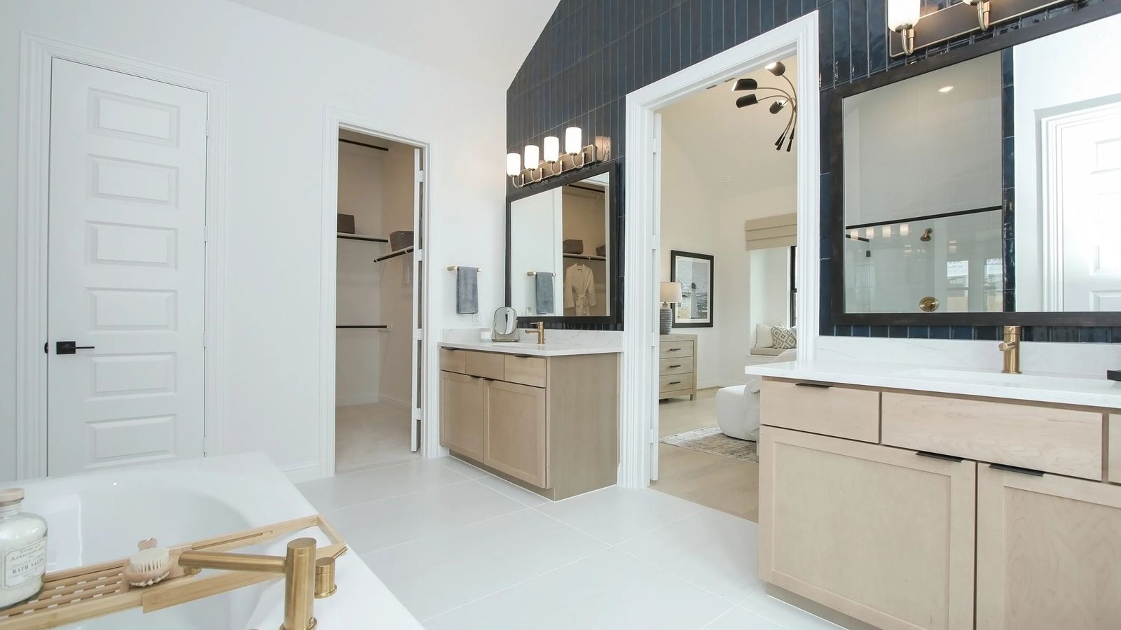 Chic dual vanities, gold fixtures highlight elegance in Coastal Point's upscale design.