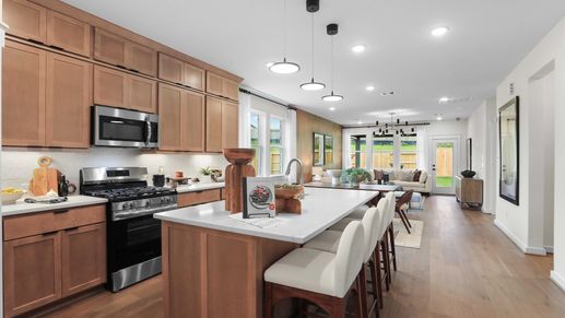 Elegant wood cabinetry and a sleek island enhance this Mostyn Springs kitchen's refined ambiance.