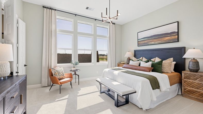 This Southern Pointe bedroom offers elegance with expansive windows, luxe finishes, and modern lighting.