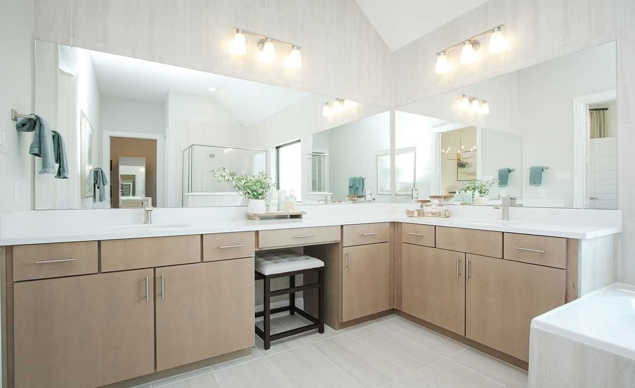 Experience refined elegance with light wood cabinetry and expansive mirrors in Sunterra's serene oasis.