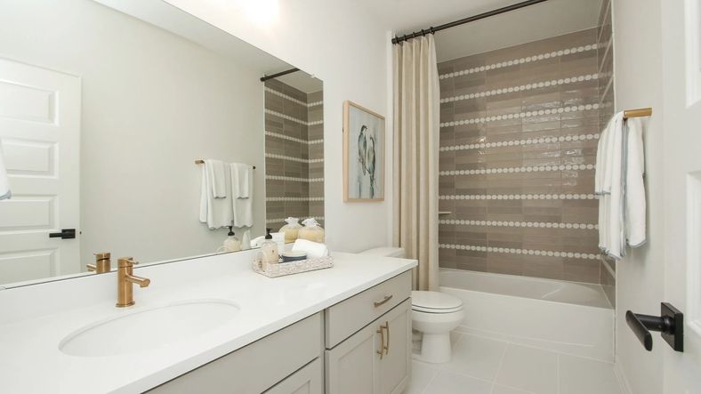 Experience elegance with sleek gray cabinetry and luxurious gold fixtures. Unique tile design enhances this Ellis Cove haven.