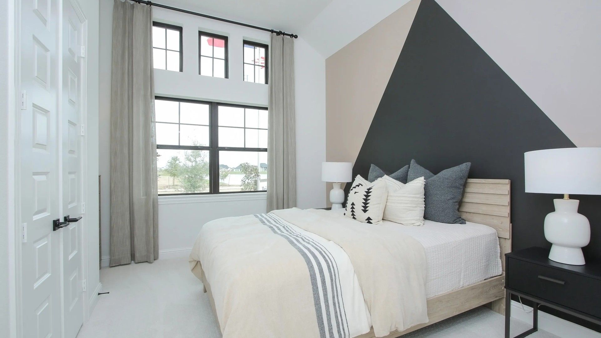 Geometric accent wall in this Coastal Point bedroom showcases modern design and sleek aesthetics.