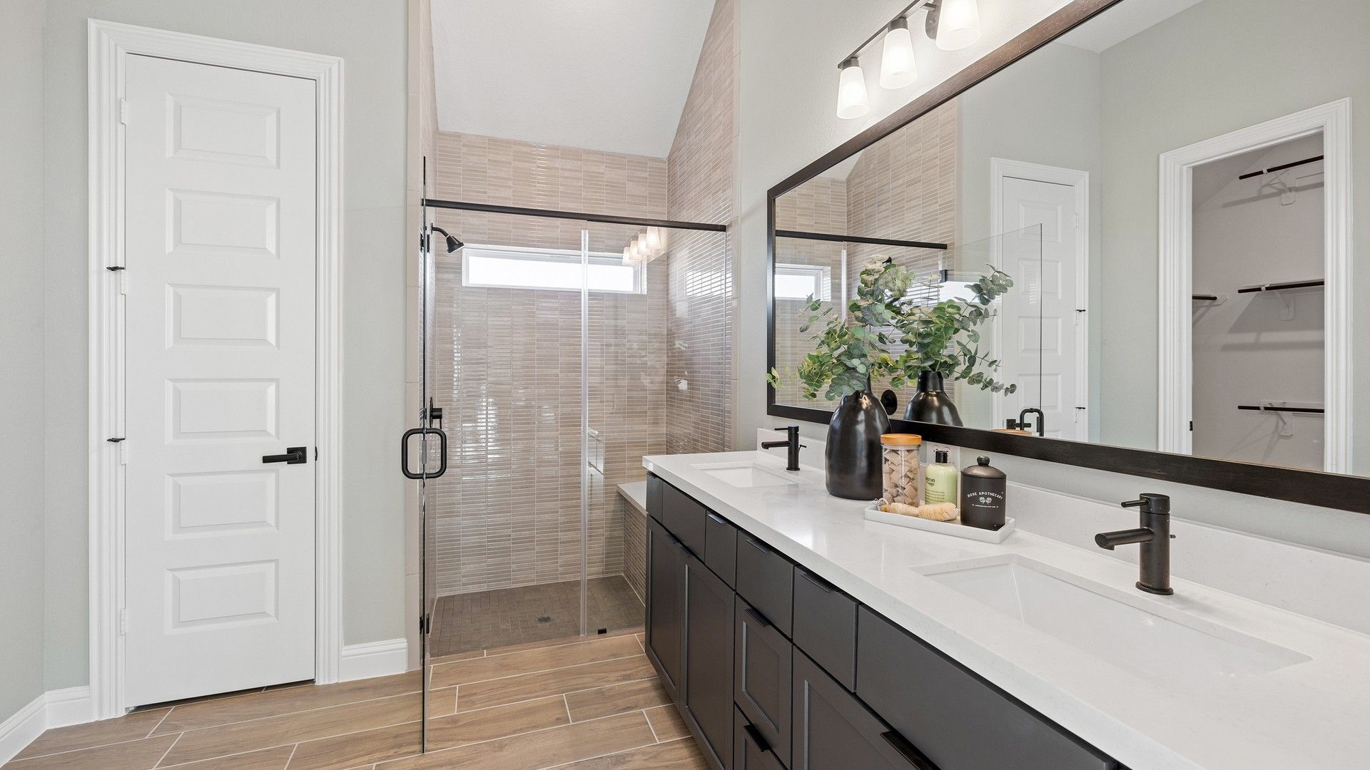 Elegantly designed bathroom showcasing quartz countertops and expansive glass shower in Southern Pointe.