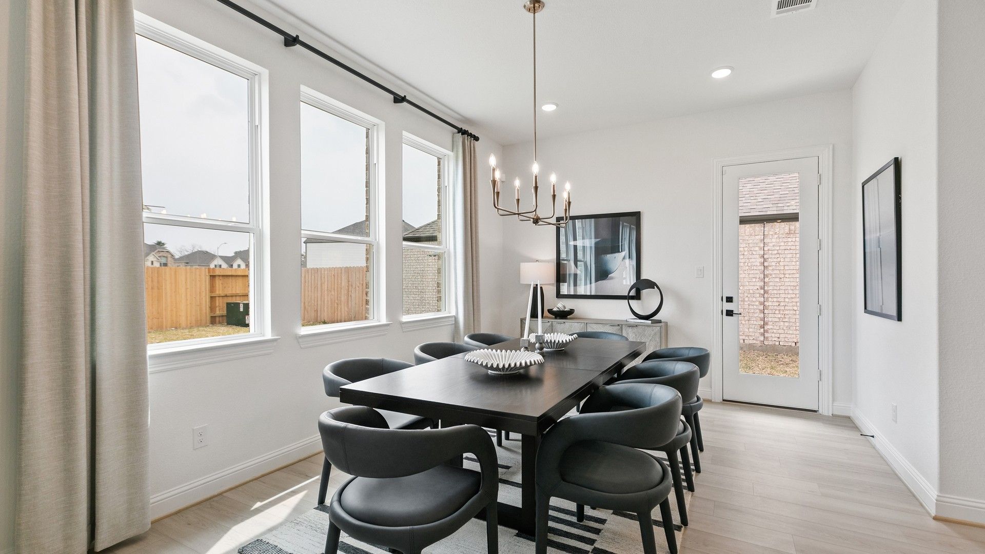 Sophisticated dining space features elegant chandelier and large windows, highlighting Houston's Park at Eldridge luxury.