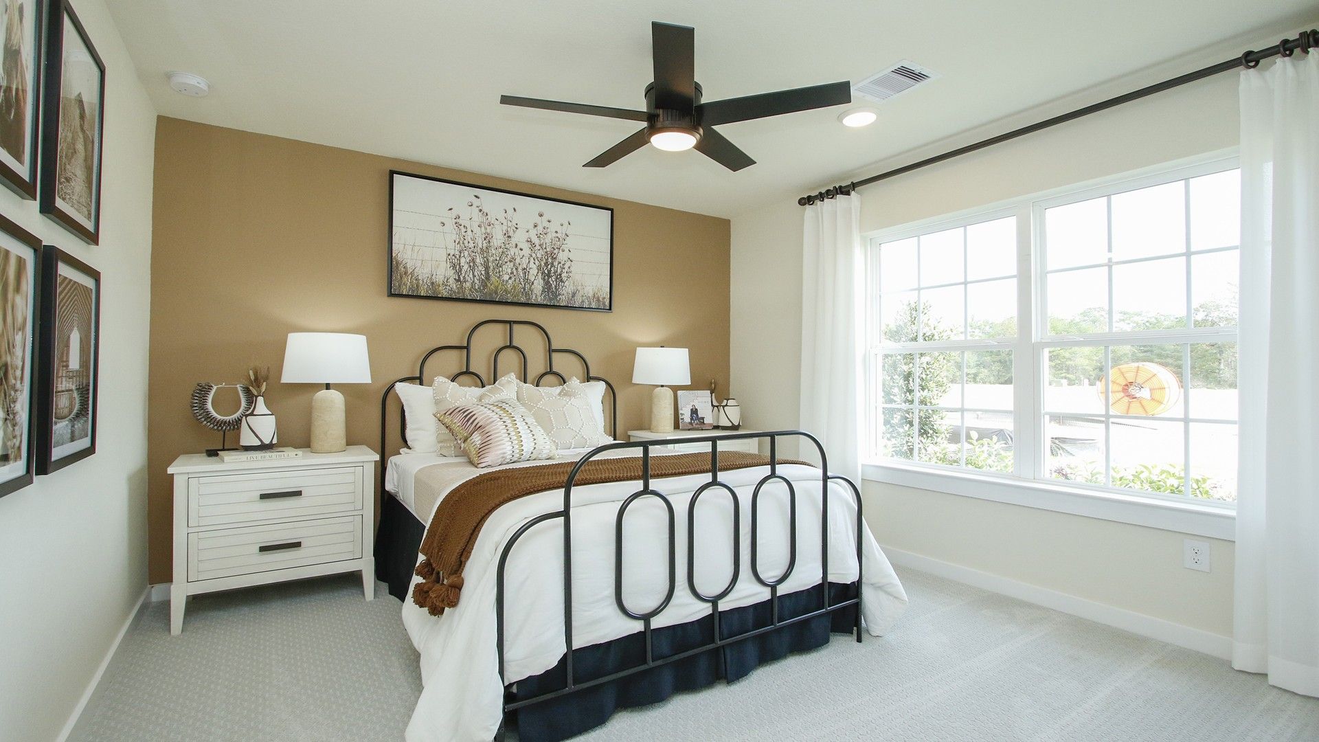Bask in natural light from expansive windows in this refined Pinehurst bedroom with chic finishes.