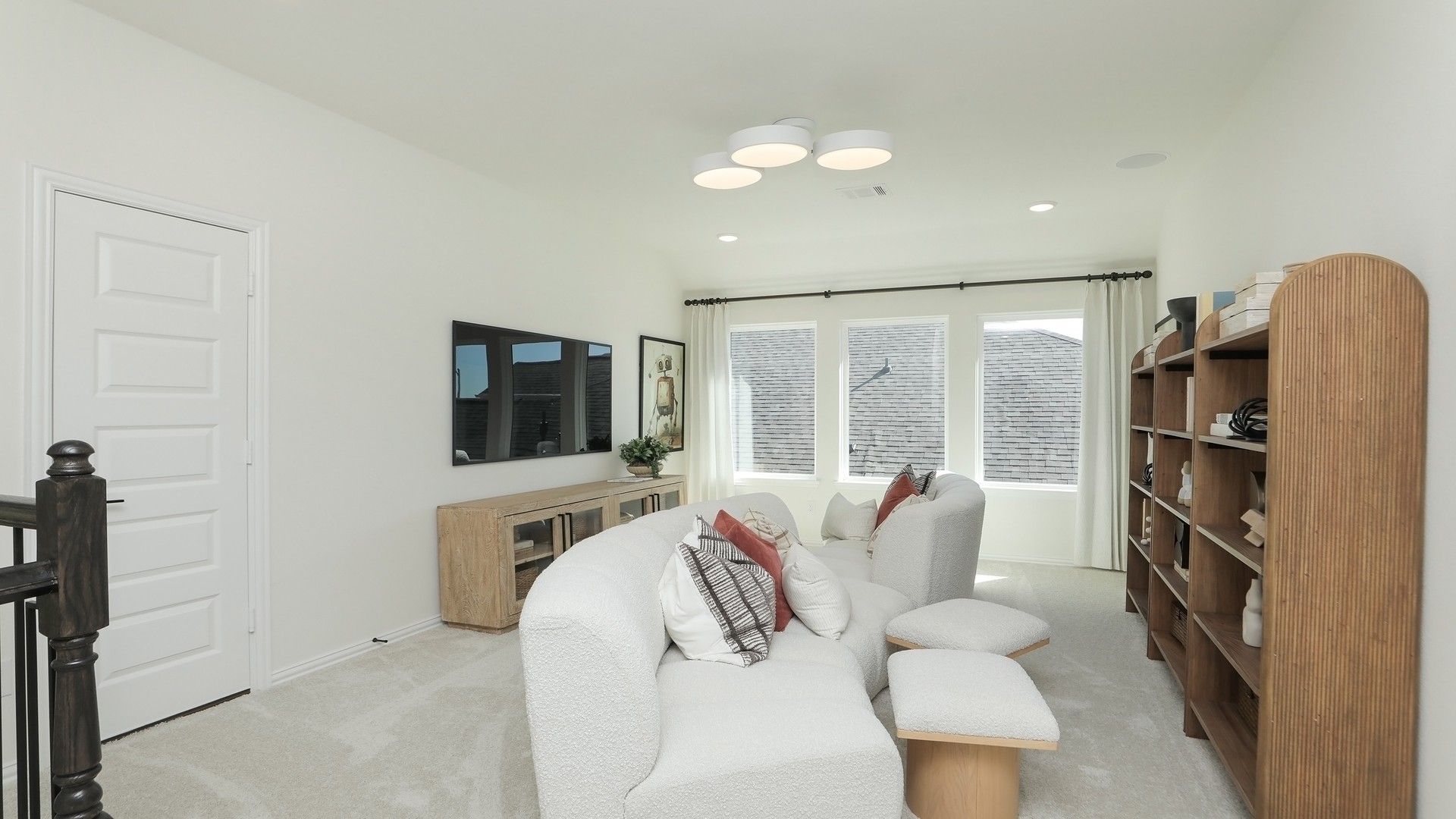 Luxurious living area with plush seating, bespoke wood shelving, and ample natural light in Brookewater.