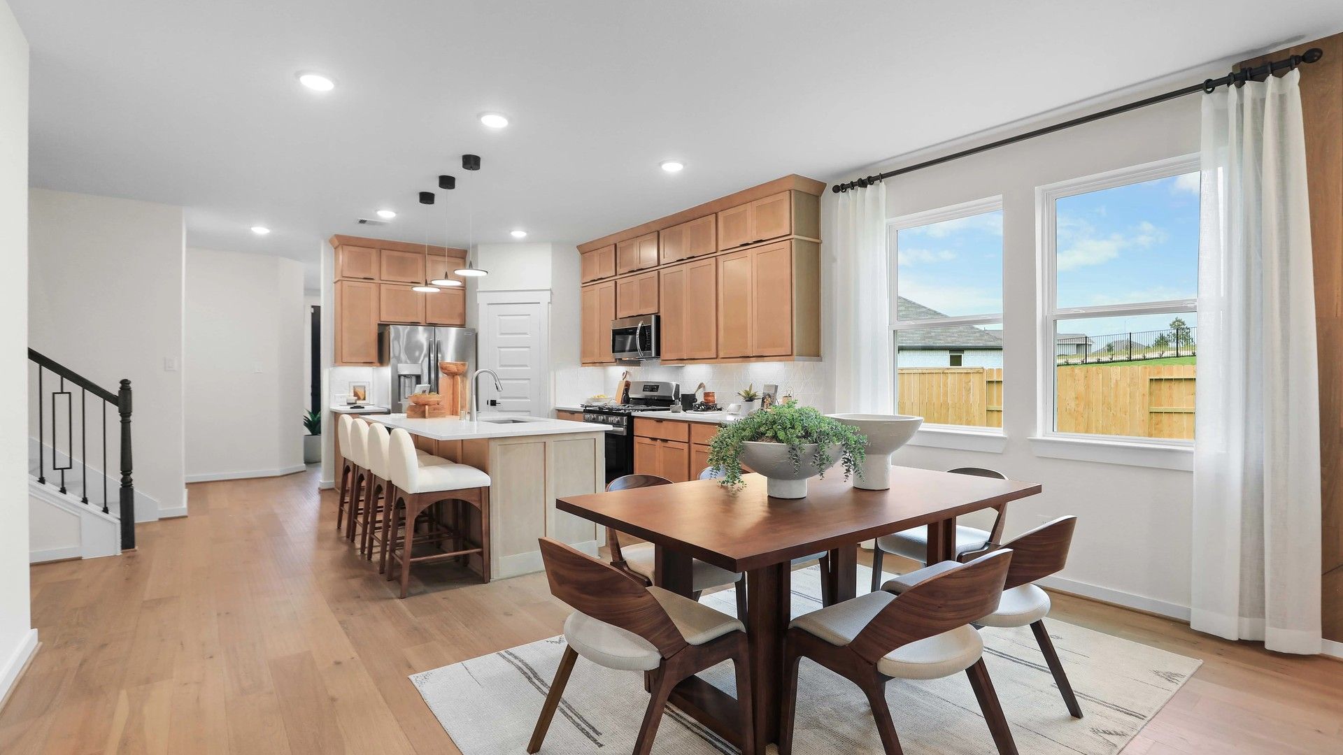 Enjoy sleek wood cabinetry and natural light in this Mostyn Springs kitchen, embodying refined modern living.