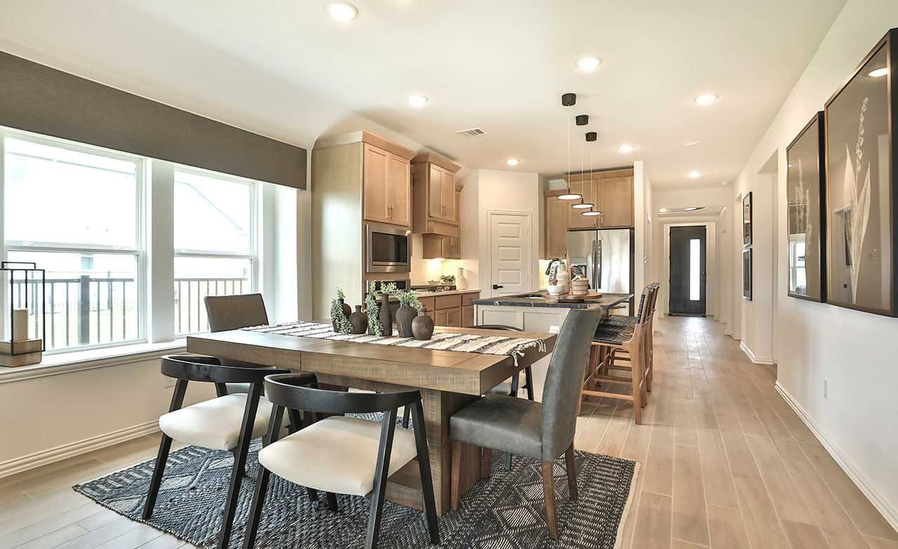 Elegant wood cabinetry and flooring highlight this Bridgeland home's open-plan dining and kitchen area.