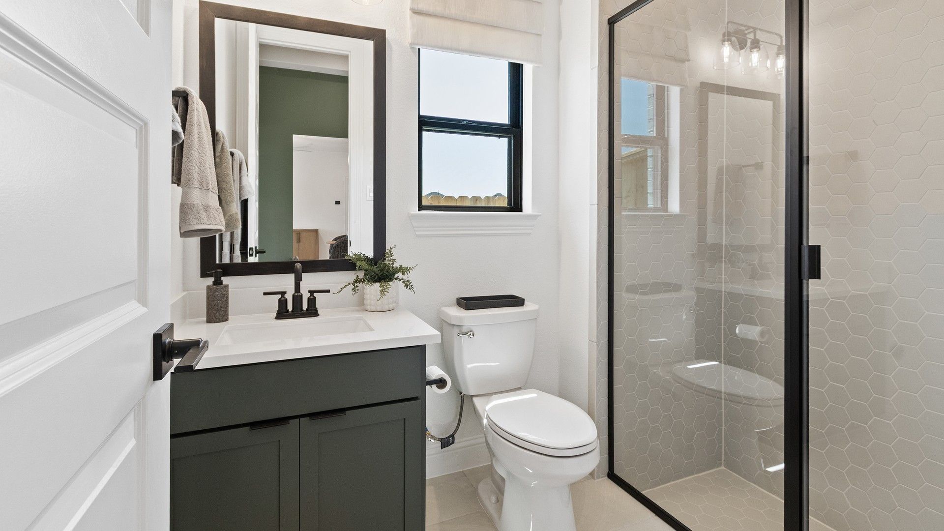 Luxurious hexagonal tiling and sleek fixtures enhance this Oakwood Estates bathroom's refined elegance.