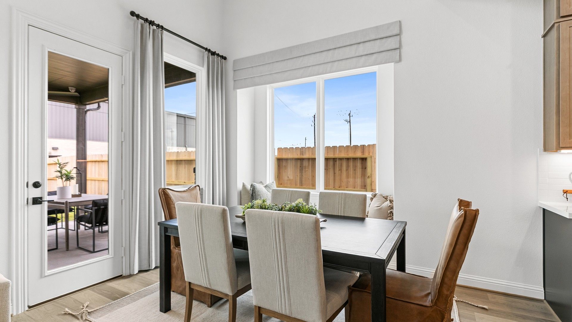 Experience refined dining in a sunlit space, showcasing expansive windows and exquisite attention to detail. Beamer Villas.