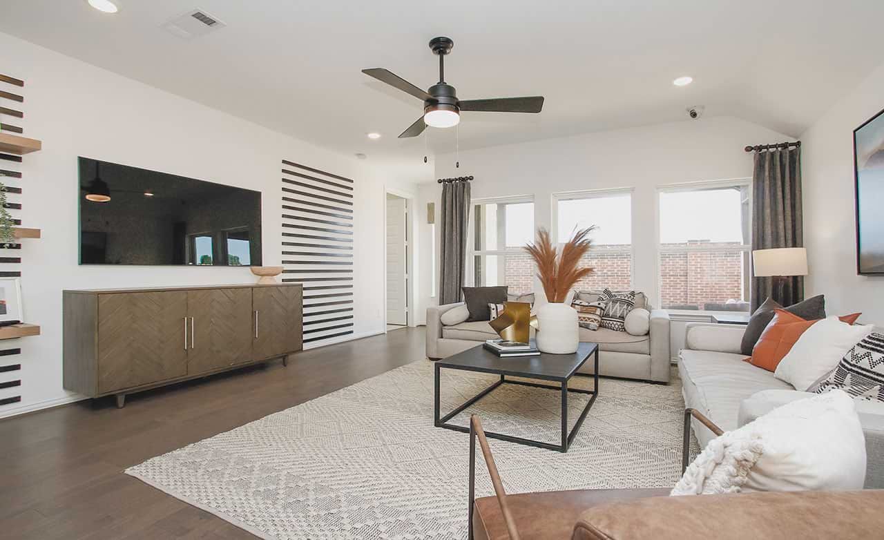 Luxurious living room in Cypress Green featuring a chic striped wall, stylish furnishings, and expansive windows.