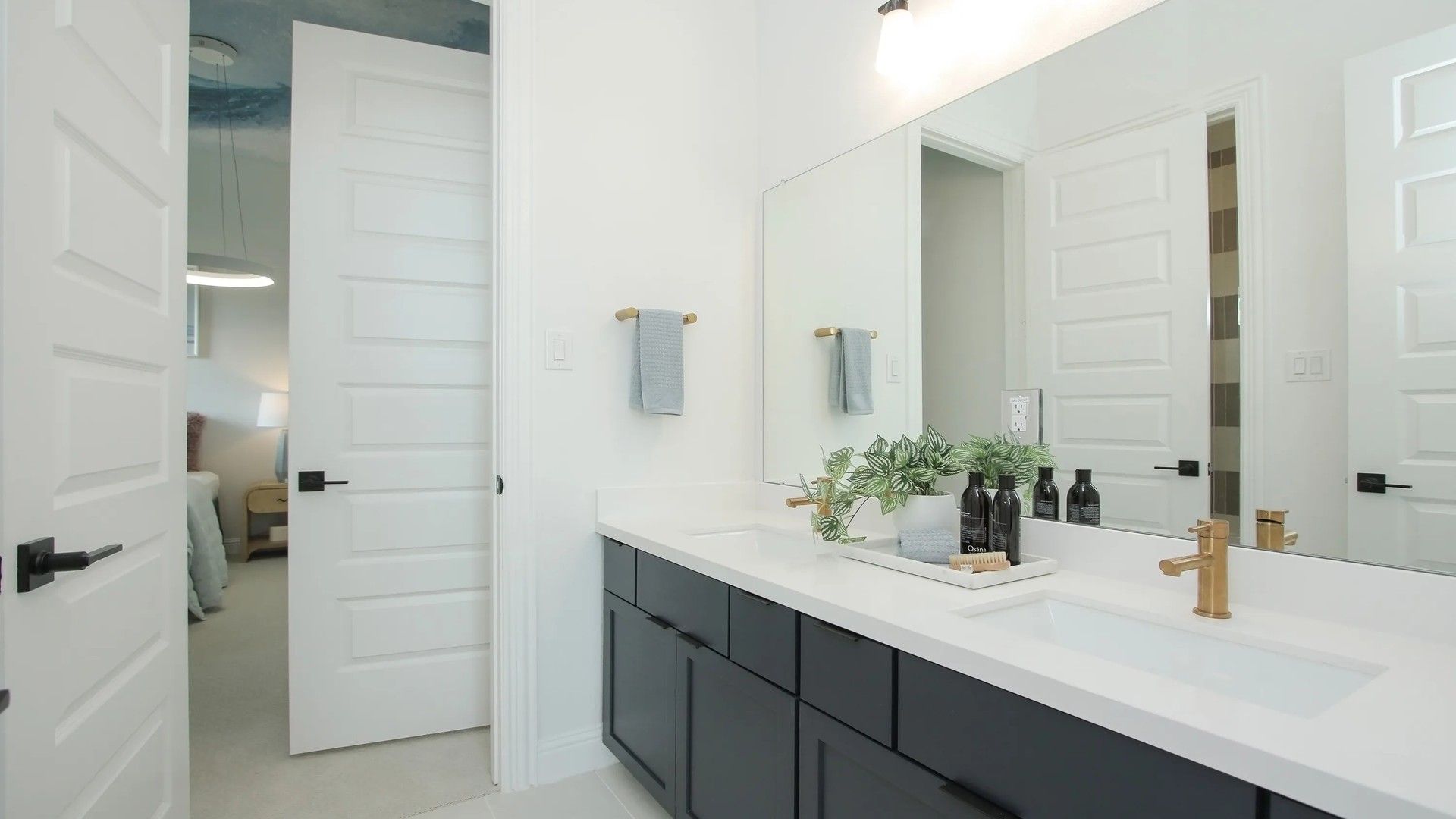 Elegant dual sinks paired with chic gold fixtures and spacious black cabinetry in Coastal Point.