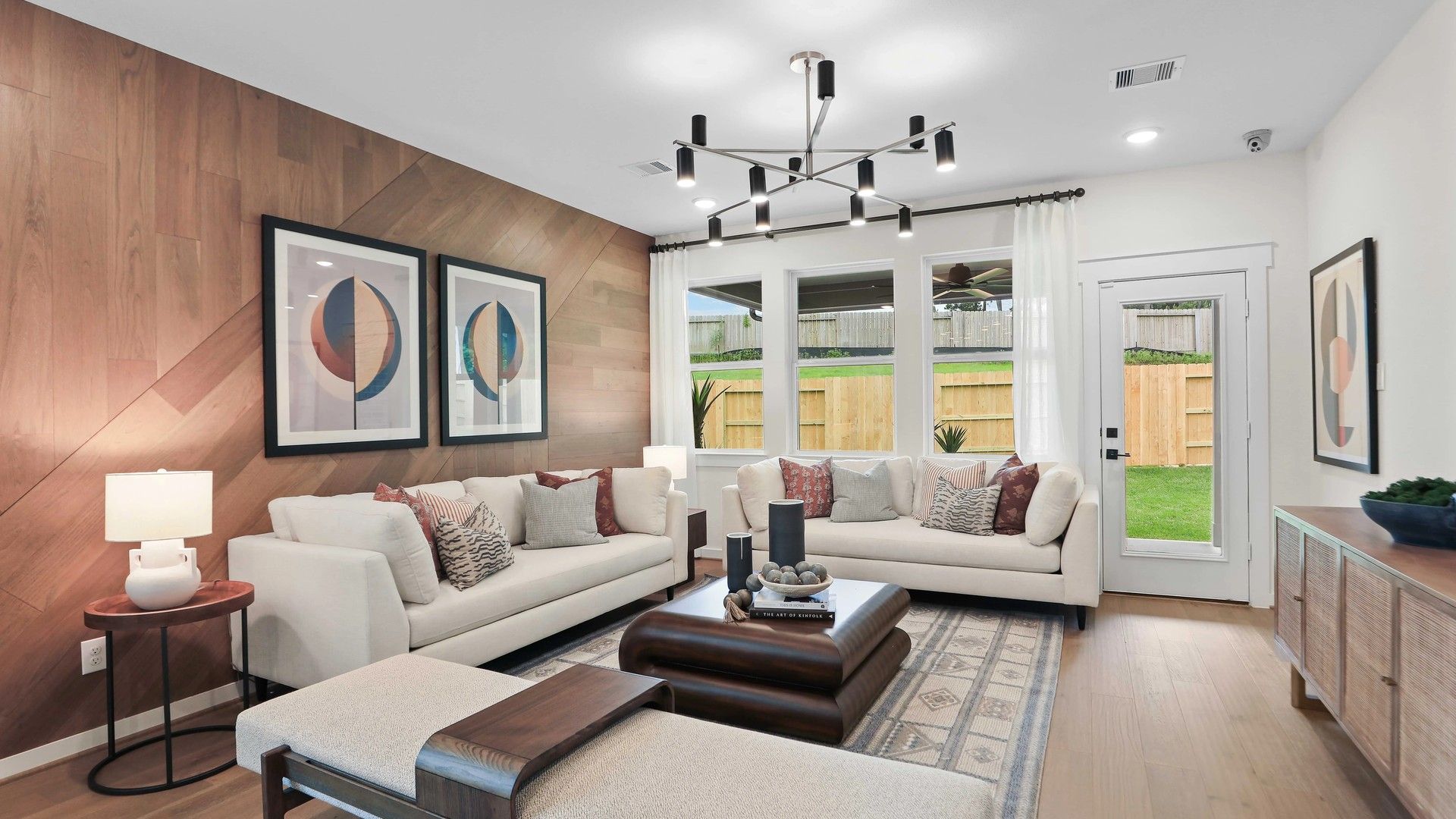 Experience elegance with a wood-paneled accent wall and chic lighting in Mostyn Springs' high-end living space.