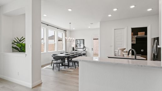 Luxurious open-plan dining with elegant chandelier and premium hardwood floors in Park at Eldridge, Houston.