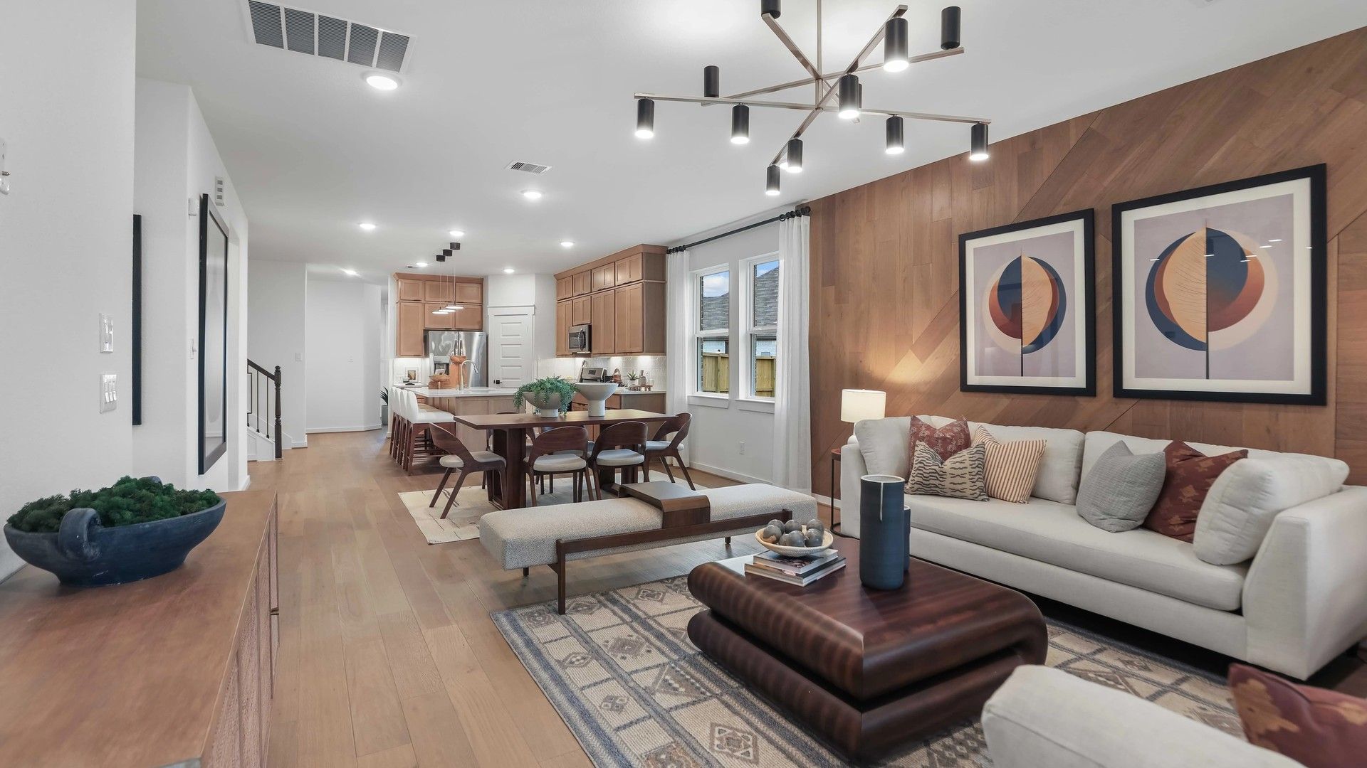 Luxurious wood-paneled walls and chic chandelier enhance this Mostyn Springs living space's elegance.