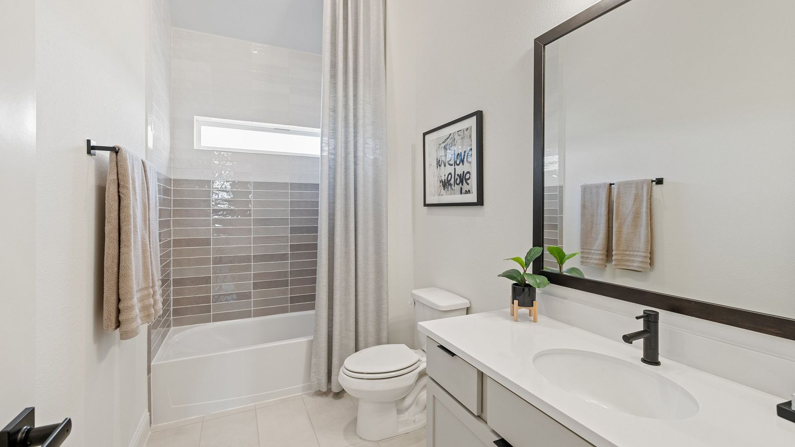 Elegant modern tiles complement a sleek white vanity in Southern Pointe. Experience luxury in every detail.