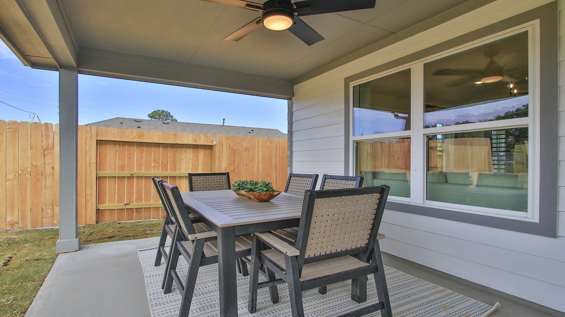 Elegant covered patio features a modern ceiling fan and stylish dining set in Pinehurst.