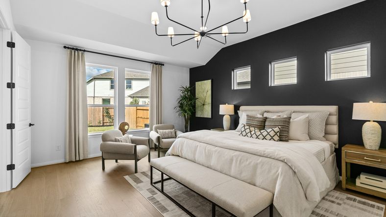 Luxurious River Ranch bedroom with a striking black accent wall and stylish modern chandelier.