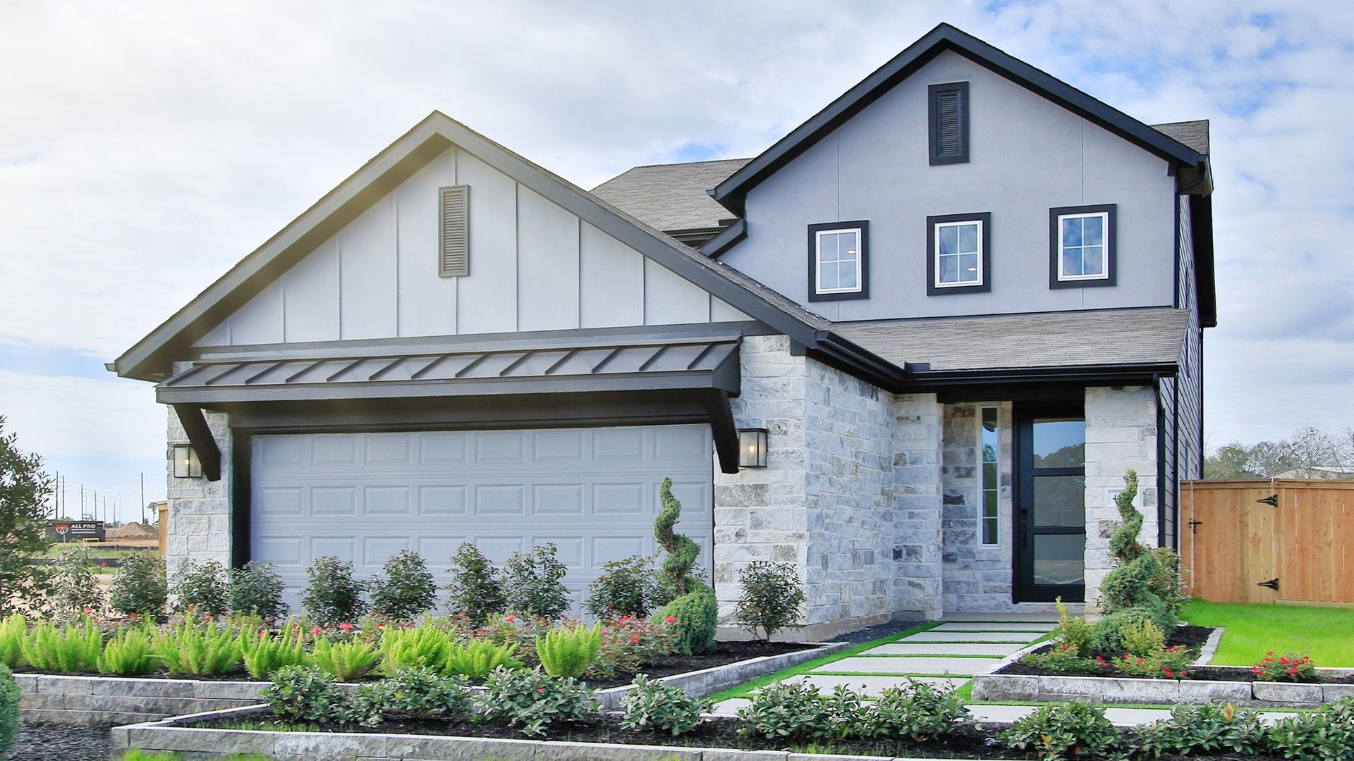 Luxurious stone facade and pristine landscaping in the Colony at Pinehurst, Texas, offer refined elegance and charm.