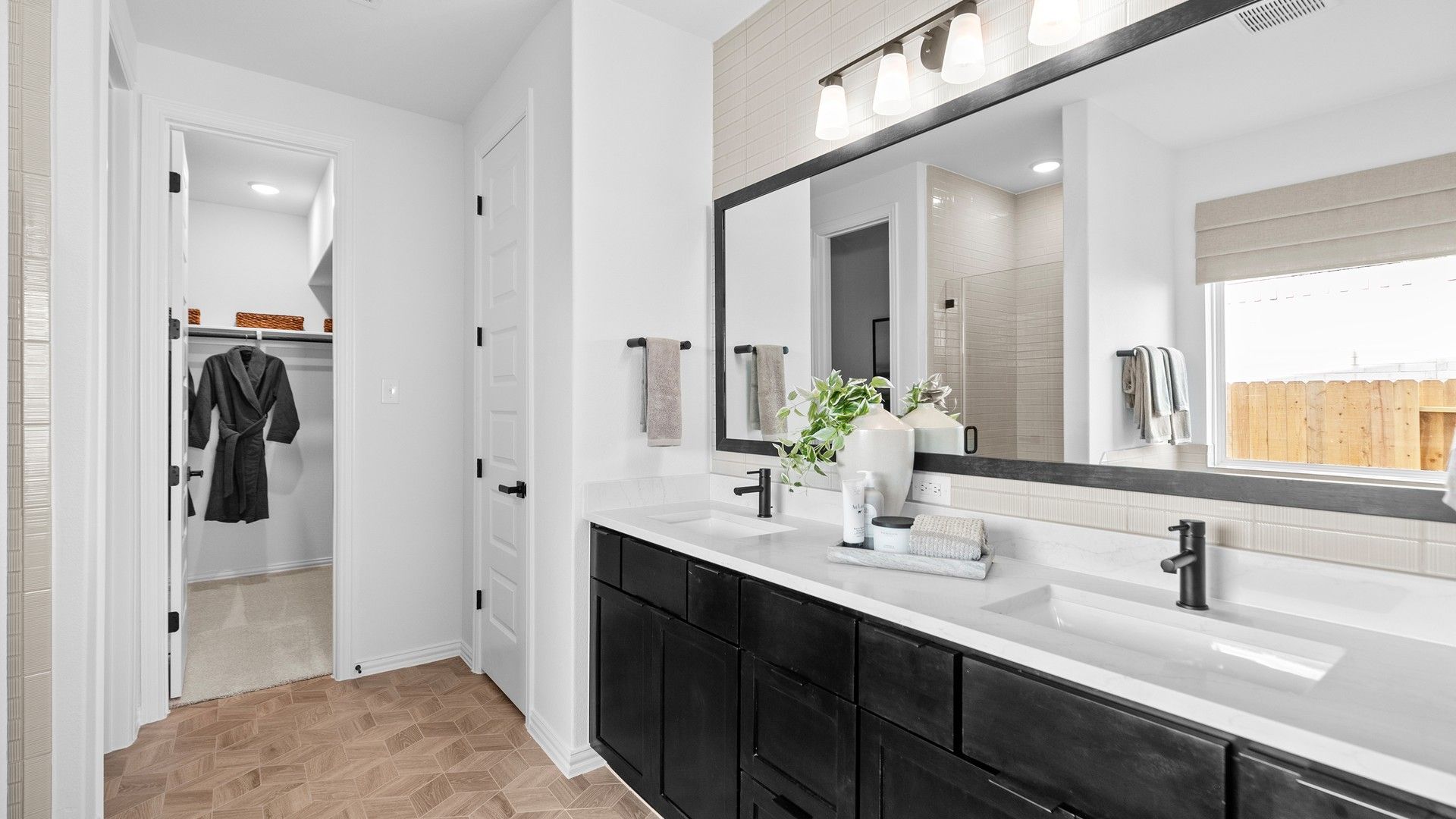 Elegant black cabinetry, geometric pattern flooring, and sleek fixtures elevate this River Ranch bathroom retreat.