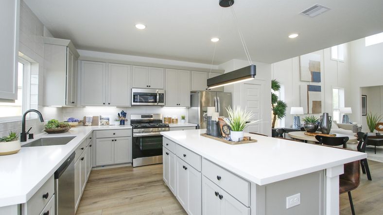 Luxurious Pinehurst kitchen boasts sleek cabinetry, expansive island, and stainless steel appliances.