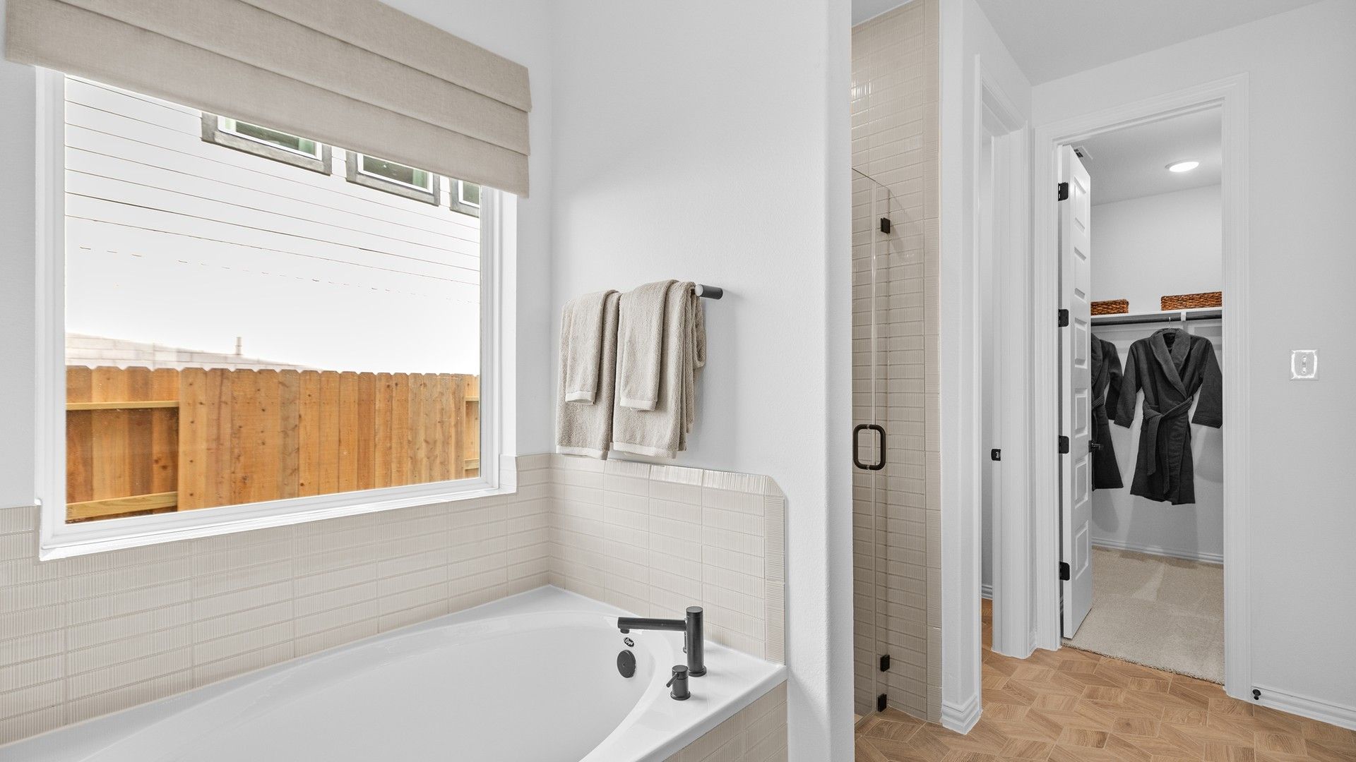 Luxurious tub and glass-enclosed shower with exquisite tilework in River Ranch.