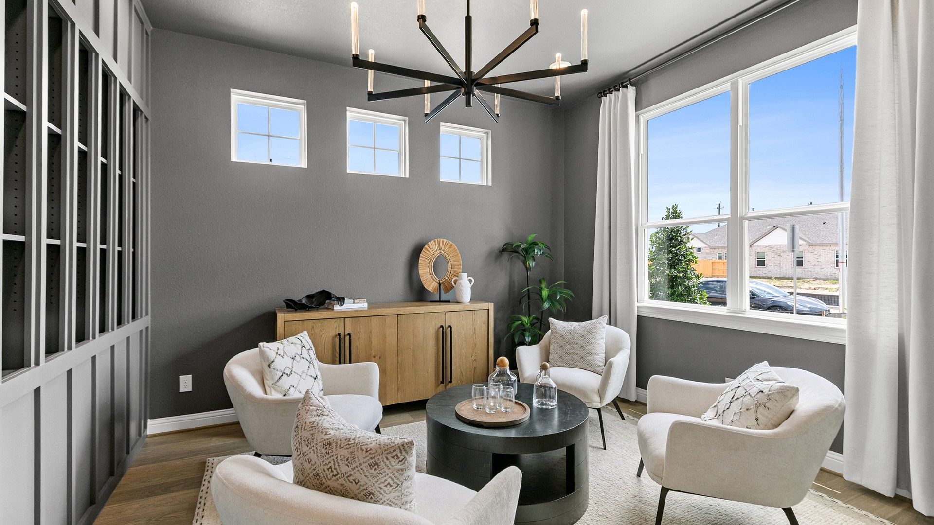Exquisite grey-walled room featuring a sleek chandelier and grand windows in Beamer Villas.
