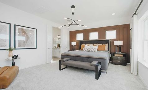 Luxurious bedroom with rich wood accent wall, stylish chandelier, plush carpet in Cypress Green.
