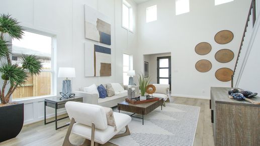 Soaring ceilings and elegant wood accents define this stylish Colony at Pinehurst, Texas living room.
