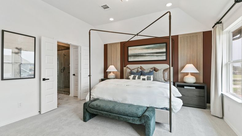 Elegant four-poster bed and modern lighting create a chic ambiance in this Park at Eldridge bedroom.