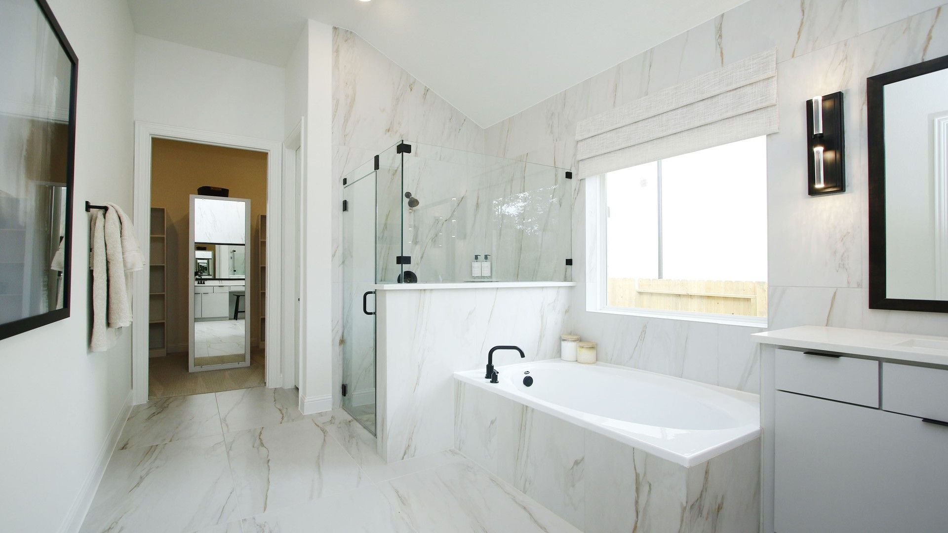 Sophisticated marble tiles grace this Woodlands Hills bathroom, boasting a sleek glass shower and sumptuous tub.