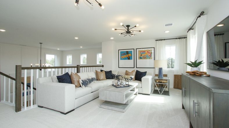 Discover the chic elegance of a spacious living room featuring plush seating, bespoke lighting, and rich textures in Colony at Pinehurst.